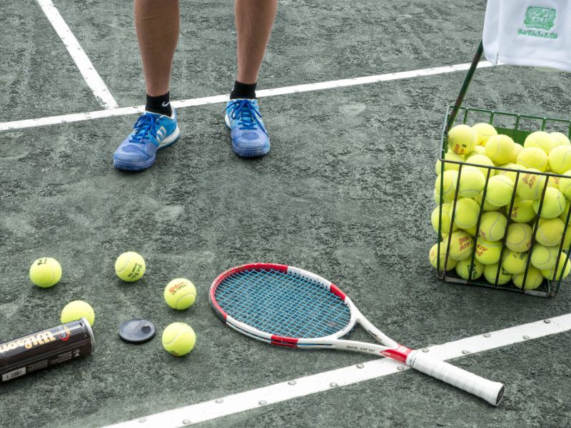close up tennis balls and racquet