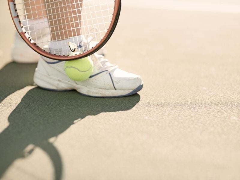 close up of sneaker and tennis ball