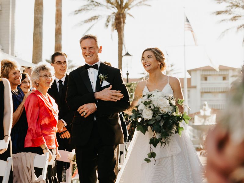 bride and father of the bride walk down the aisle
