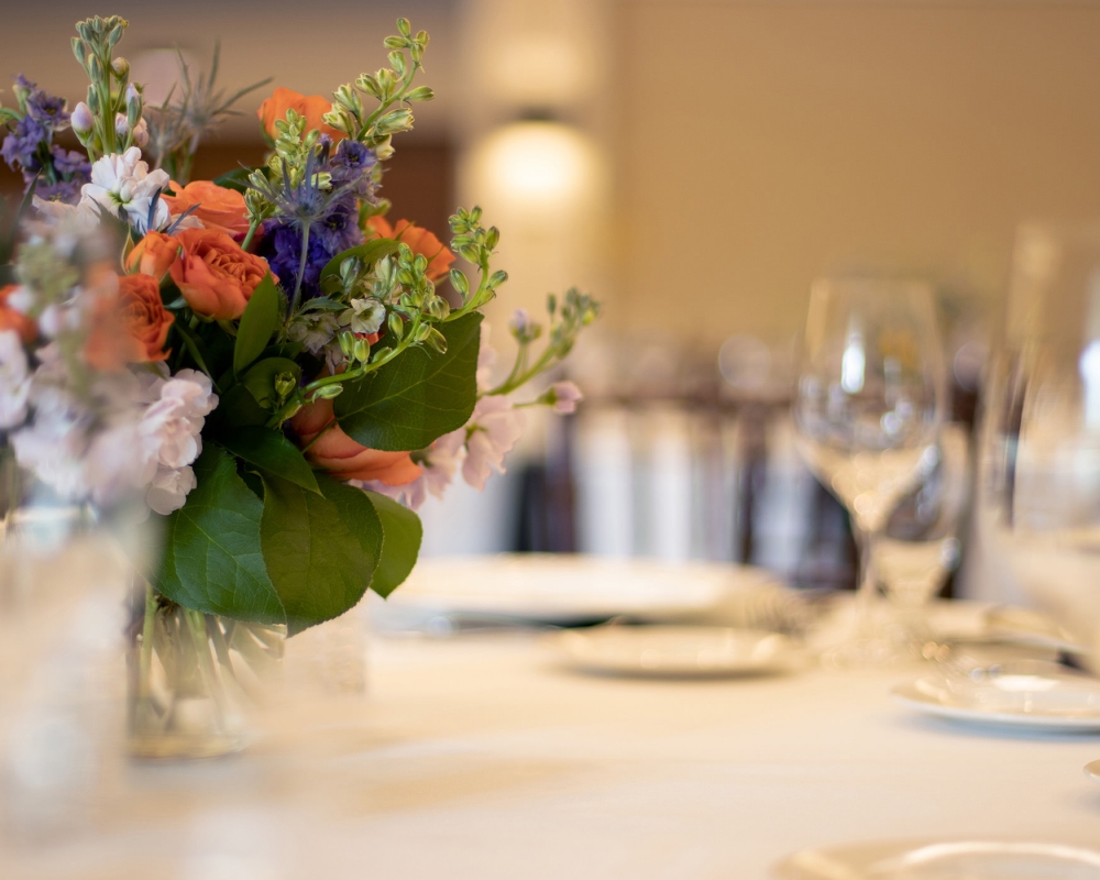 Floral arrangement on a set table inside a restaurant