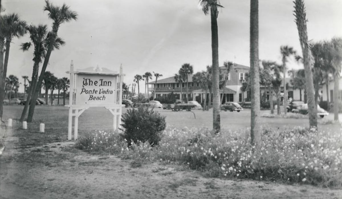 A black and white photo of palm trees and the Historic Inn building in the early days of Ponte Vedra Inn & Club.