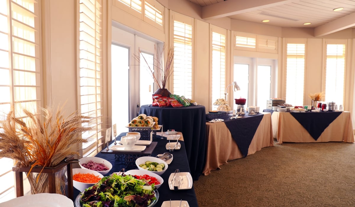 Catering food tables lined against the venue windows