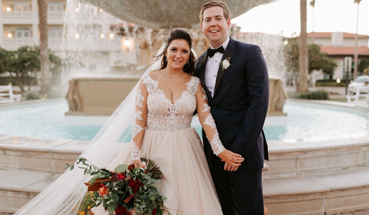 A bride and groom smile in front of the iconic fountain at Ponte Vedra Inn & Club.