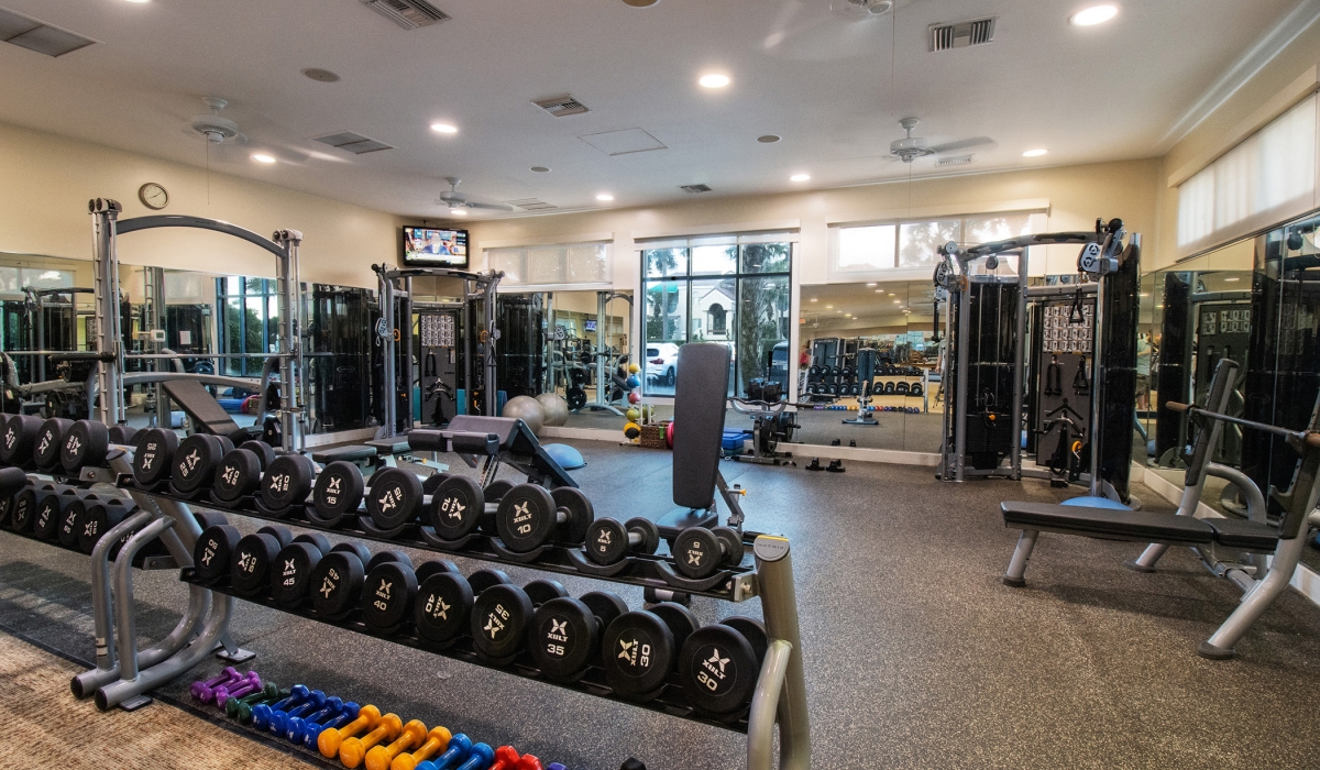 Fitness facility with a rack of dumbbells in the forefront