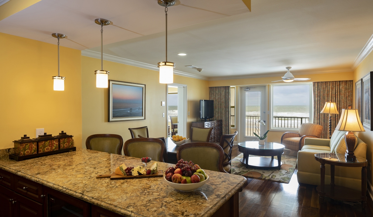 kitchen island with bar stools and living area in the background