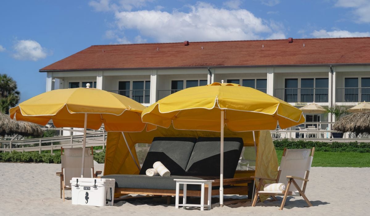 photo of beach with a cabana and two lounge chairs with side table