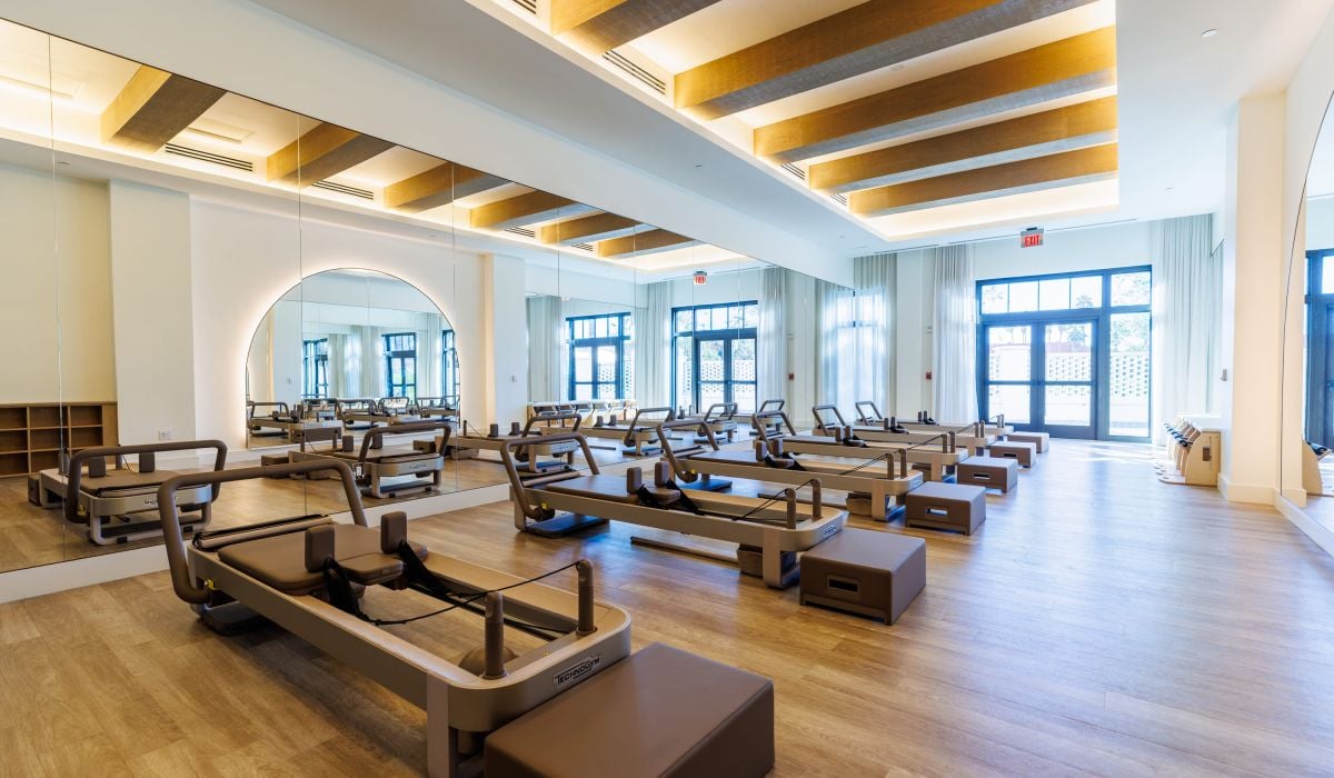 a pilates room with machines in a line 
