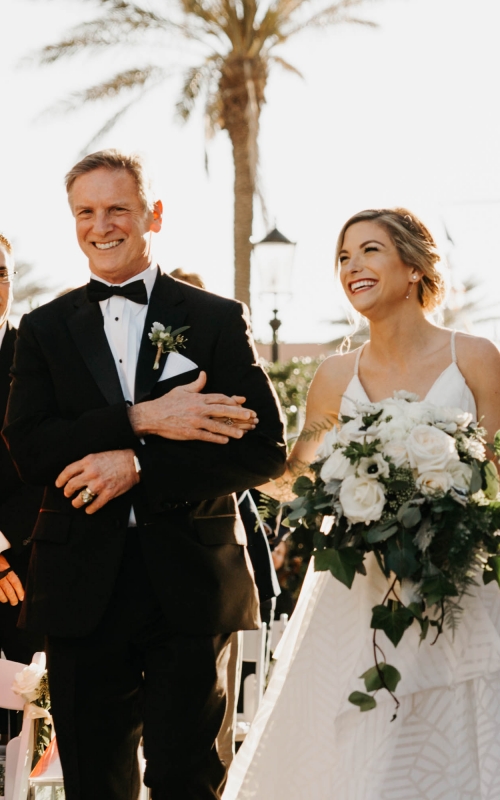 bride and father of the bride walk down the aisle