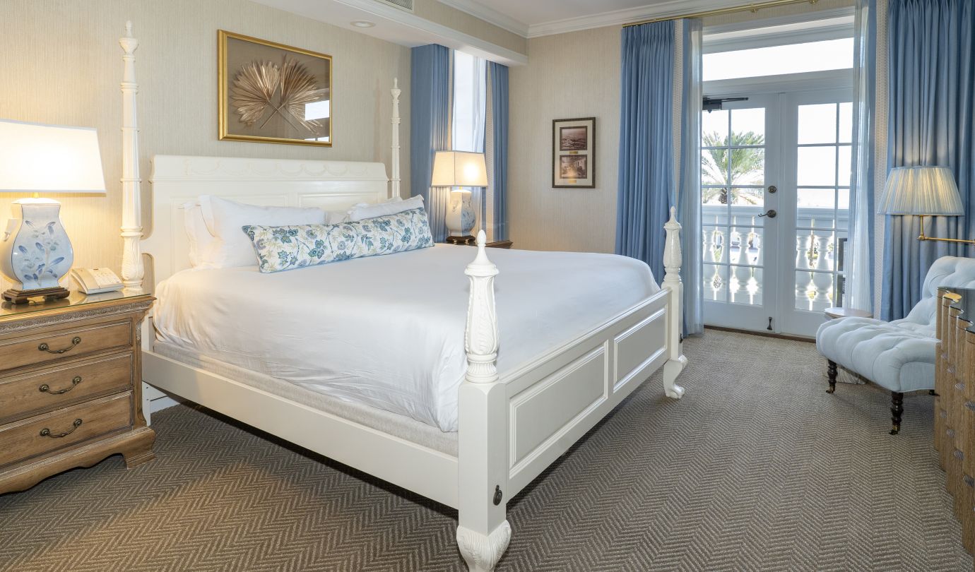 Image of bedroom with bed and large doors to outdoor balcony.