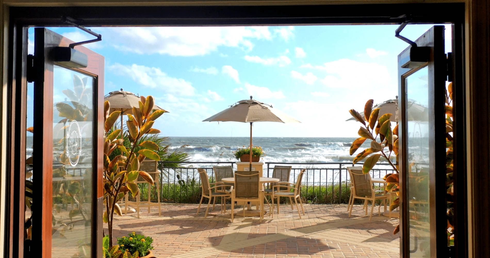 view of oasis patio through open doors