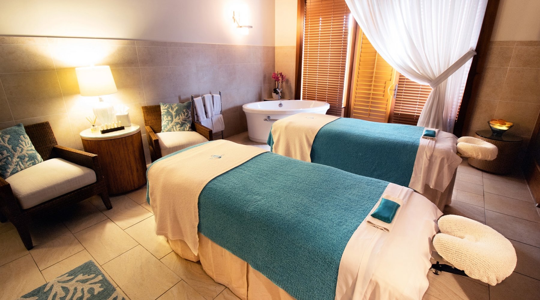 Twin massage tables set and ready for a couples massage with chairs in the back