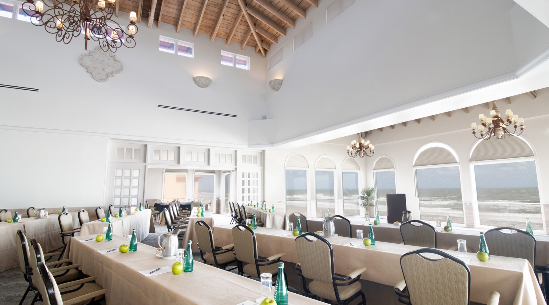 Banquet tables set and arranged facing the podium inside the Conservatory