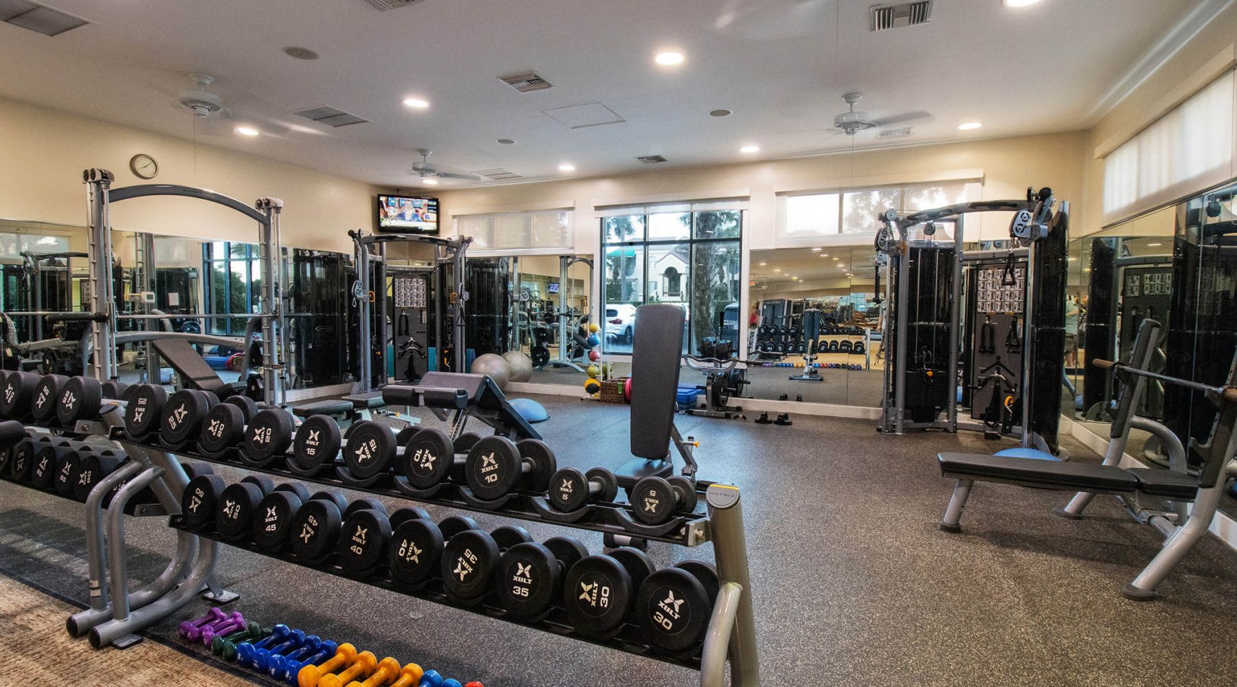 Fitness facility with a rack of dumbbells in the forefront